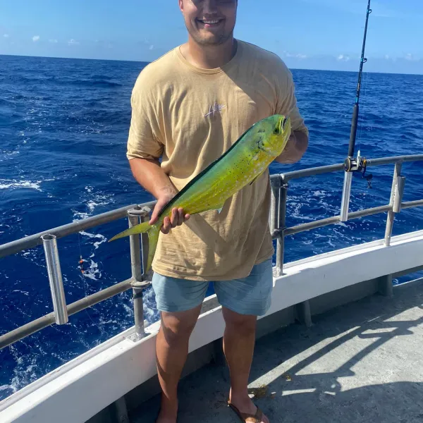 a man holding a fish on a boat in the water